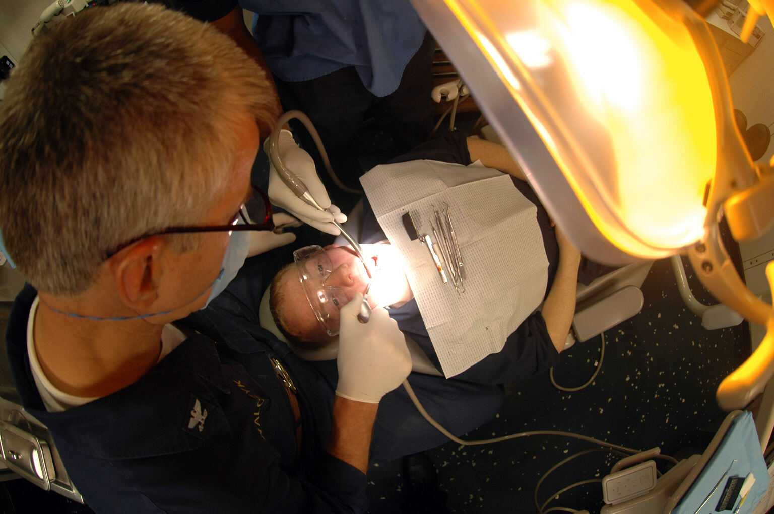 Overhead view of a dentist placing a tooth-colored filling during a treatment room procedure